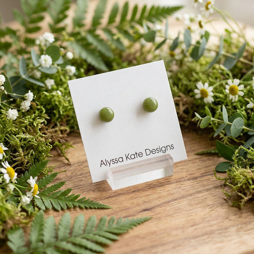 A pair of small round green stud earrings.