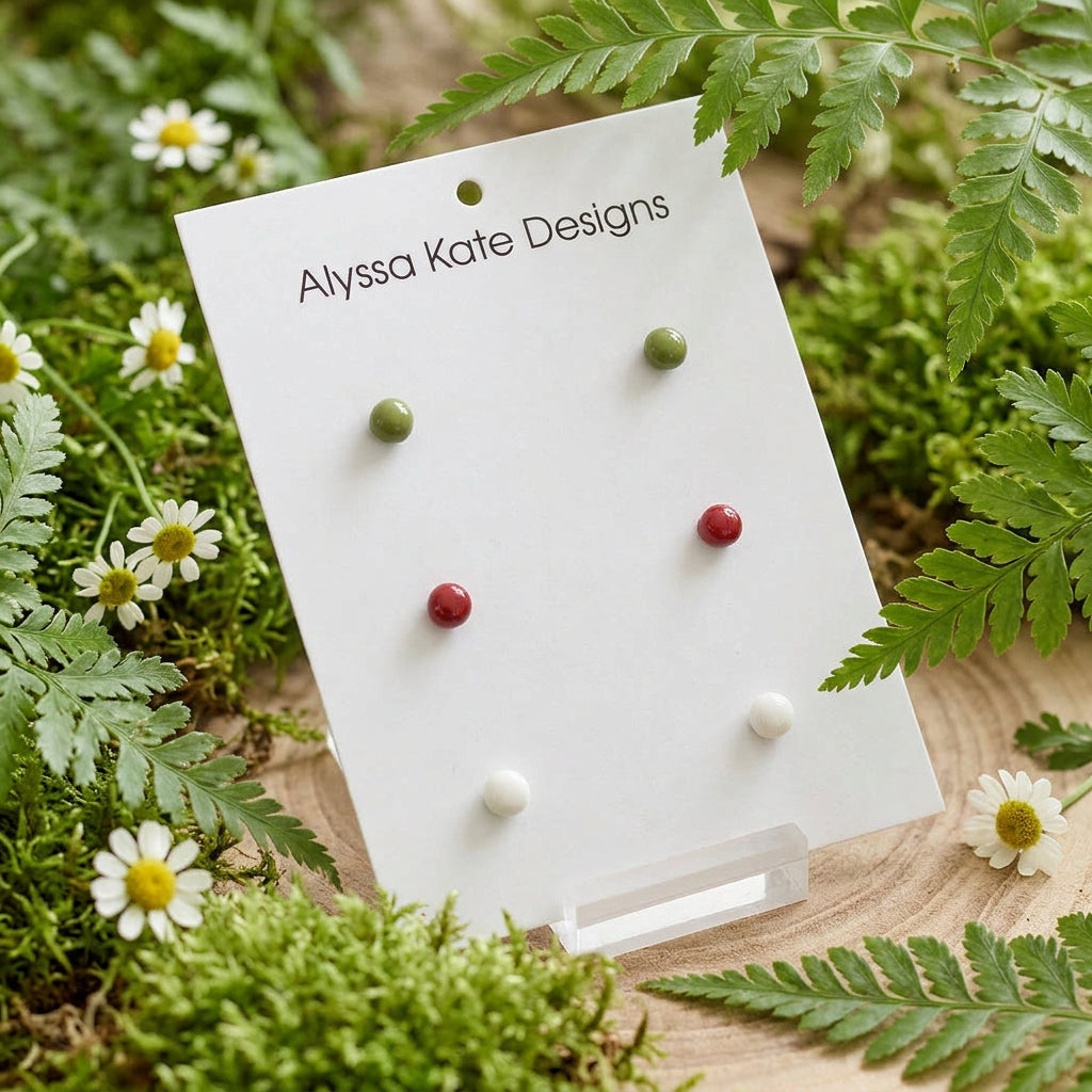 Holds six small round stud earrings in green, red, and white.