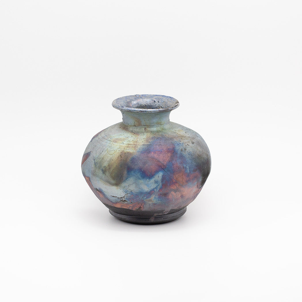 A small ceramic vase with a rounded body, short flared neck, and circular base, featuring an iridescent glaze with blended blue, purple, pink, and gold tones.