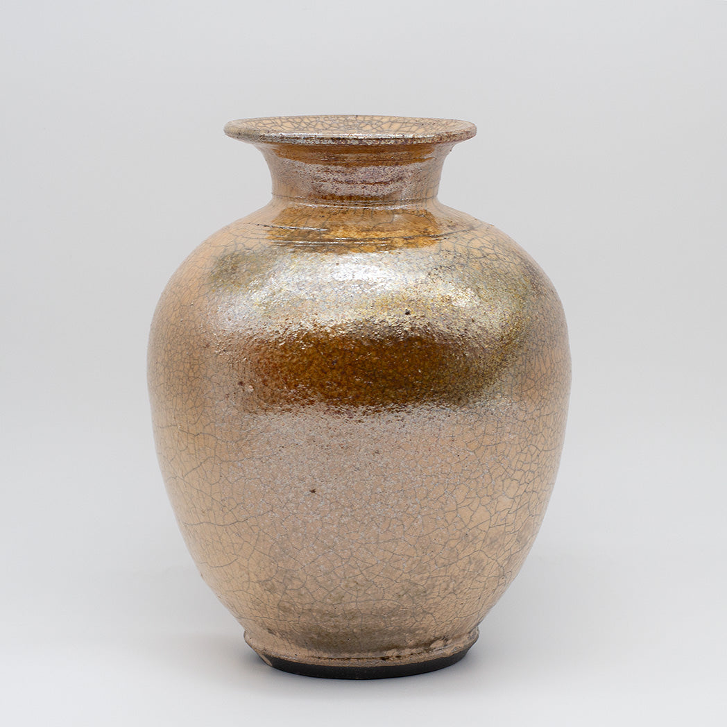 A ceramic vase with a rounded body, short flared neck, and dark base, covered in a textured metallic gold and bronze glaze with fine crackle patterns.