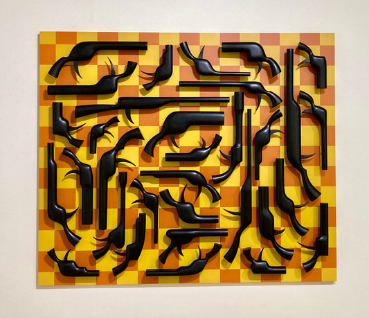 Wooden sculpture depicting multiple black guns spread across a orange and yellow checkerboard. 2020 45"x54"x4.5" painted wood Sean O'Meallie